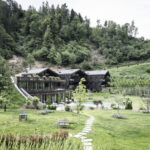 Das Apfelhotel Torgglerhof in Südtirol eingebettet in die hügelige Wiesenlandschaft