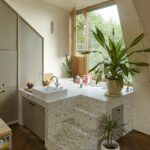 Blick aus Wohnraum auf die Badewanne auf dem Treppenpodest einer Maisonettewohnung einer Aufstockung in Lausanne