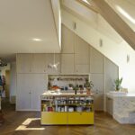 Blick aus Wohnraum auf Küche und Treppe mit eingelassener Badewanne in einem Mehrfamilienhaus in Lausanne
